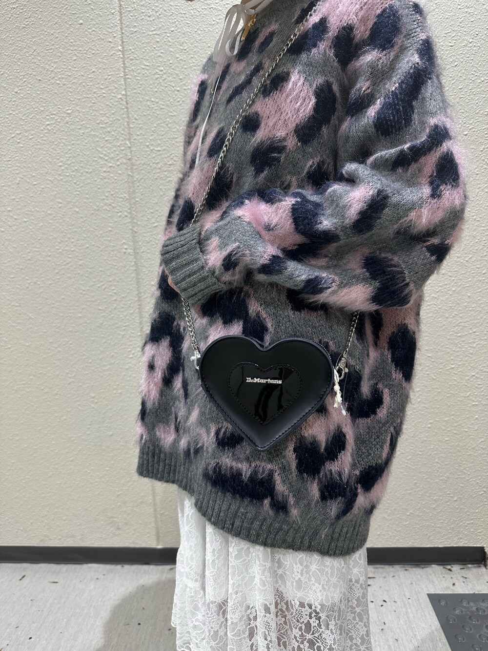 グレー系のニット/セーター、ホワイト系のスカート、ブラウン系のブーツを着用したレディースの秋コーディネートの9枚目の写真