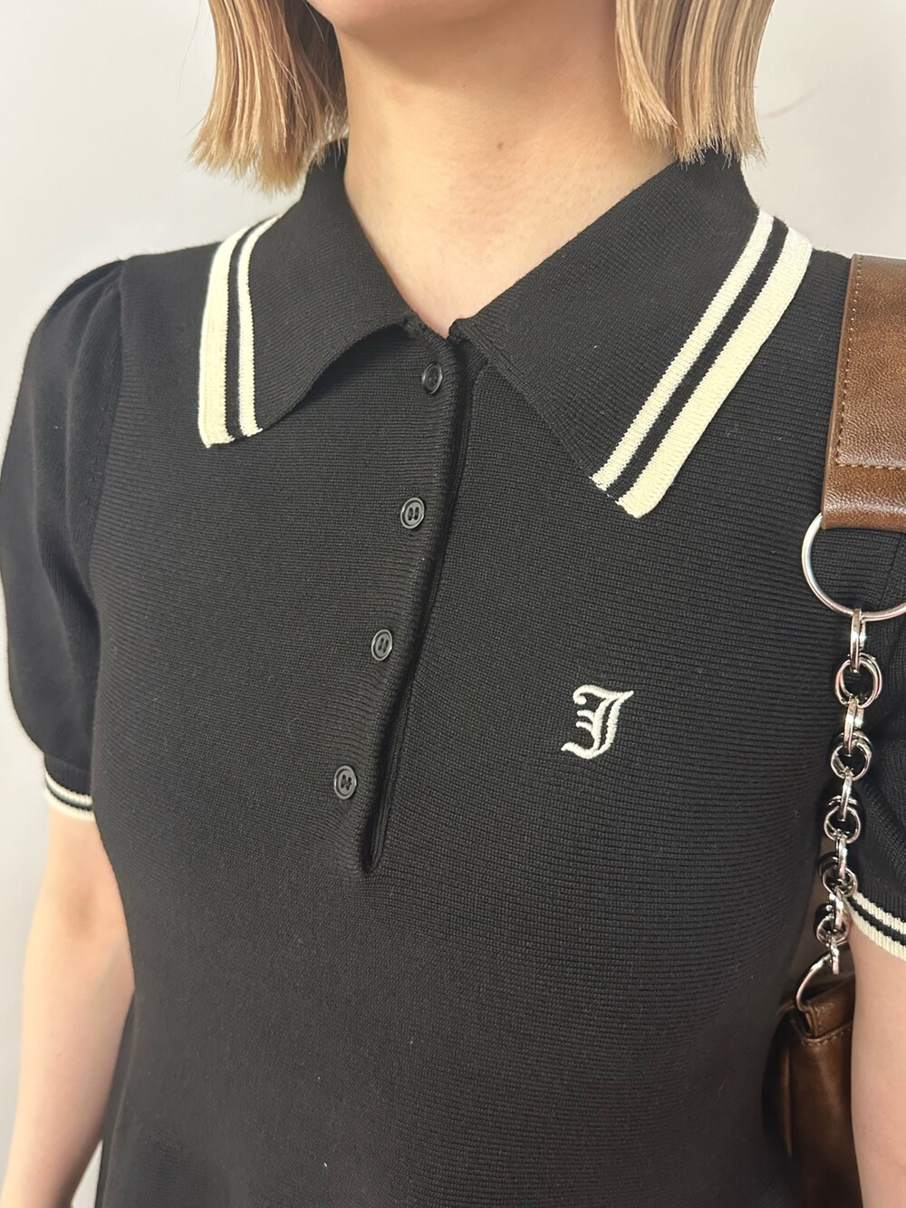 ブラック系のワンピース、ブラウン系のハンドバッグ、ブラウン系のパンプスを着用したレディースの春コーディネートの7枚目の写真