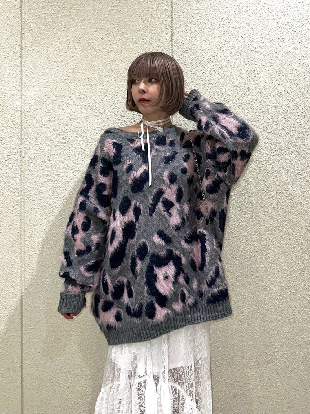 グレー系のニット/セーター、ホワイト系のスカート、ブラウン系のブーツを着用したレディースの秋コーディネートの6枚目の写真