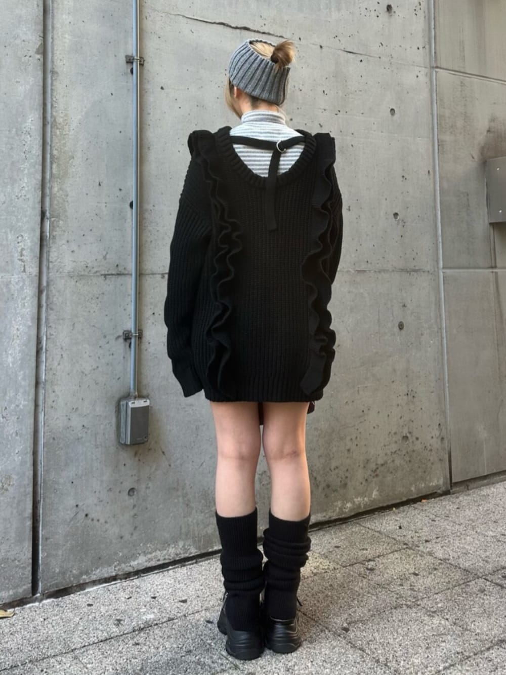 ブラック系のスニーカー、ブラック系のニット/セーター、レッド系のハンドバッグを着用したレディースの冬コーディネートの4枚目の写真