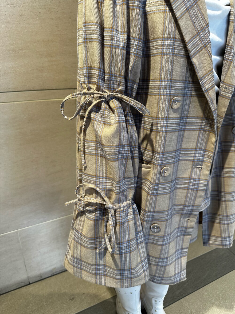 ベージュ系のテーラードジャケット、ベージュ系のスカート、ホワイト系のTシャツ/カットソーを着用したレディースの春コーディネートの7枚目の写真