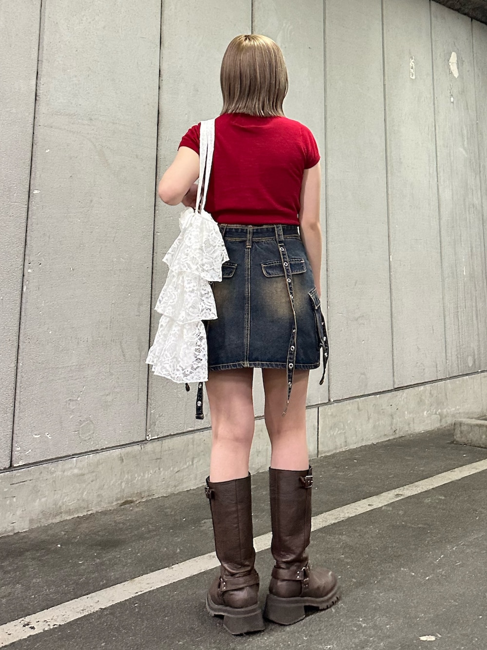 レッド系のニット/セーター、ブルー系のスカート、ブラウン系のブーツを着用したレディースの春コーディネートの5枚目の写真