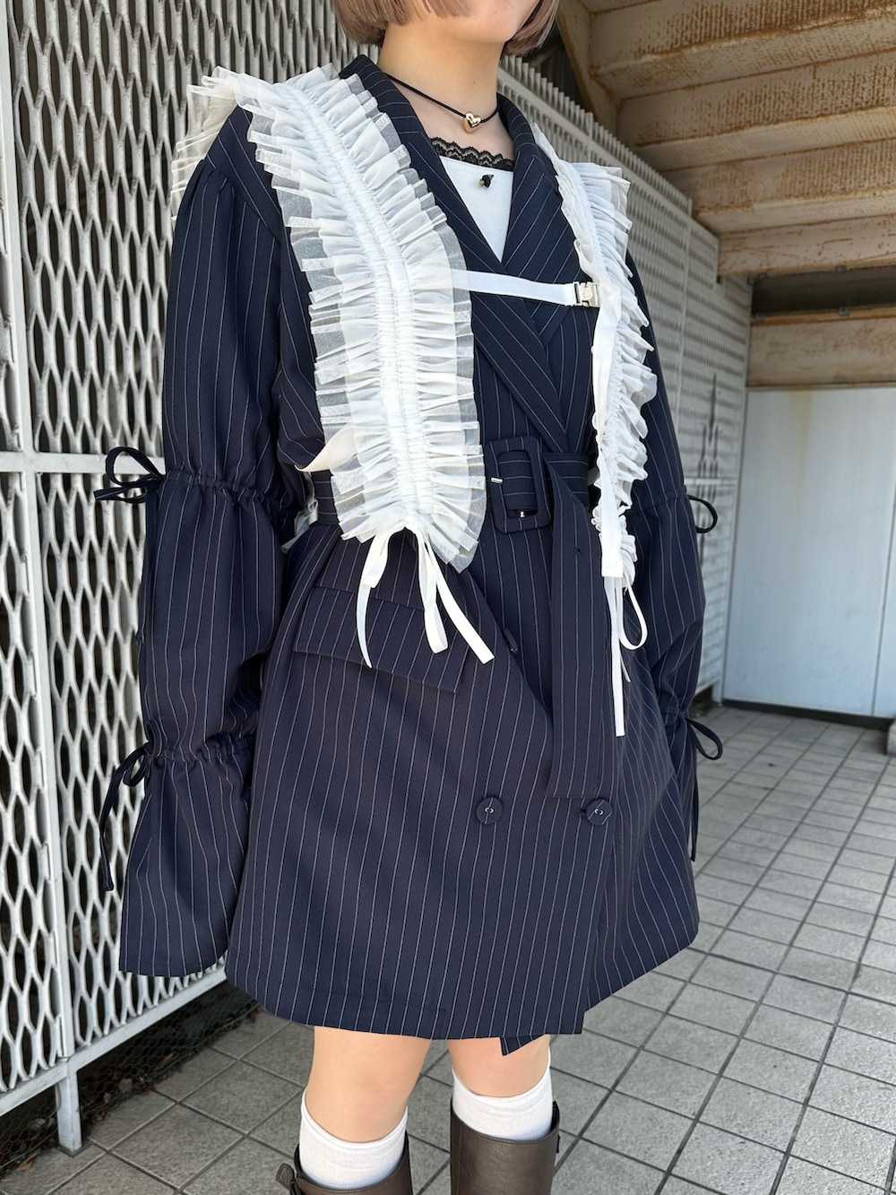 ブルー系のテーラードジャケット、ホワイト系のTシャツ/カットソー、ブラウン系のブーツを着用したレディースの冬コーディネートの8枚目の写真