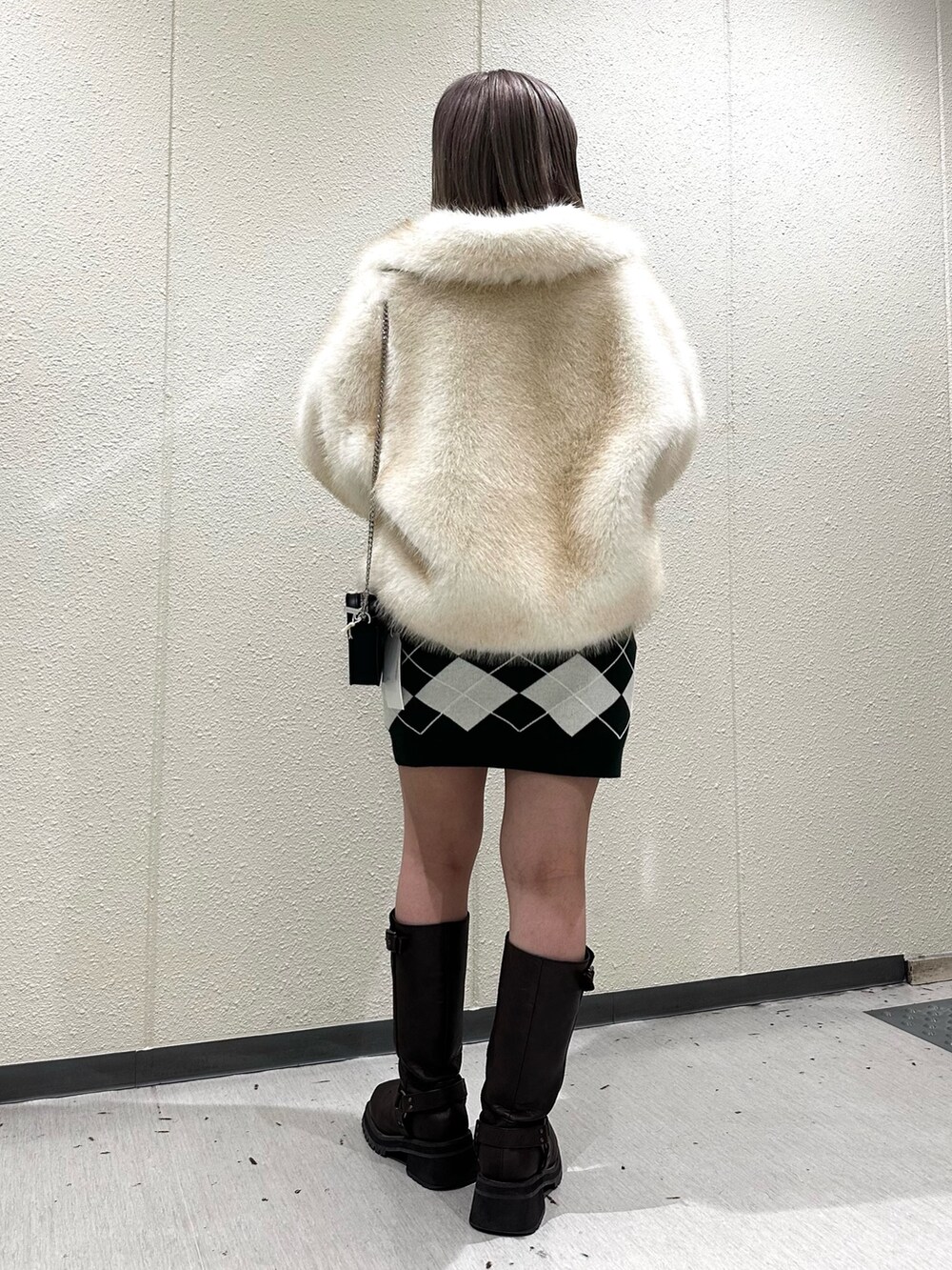 グリーン系のワンピース、ブラウン系のブーツ、ホワイト系のその他アウターを着用したレディースの秋コーディネートの5枚目の写真