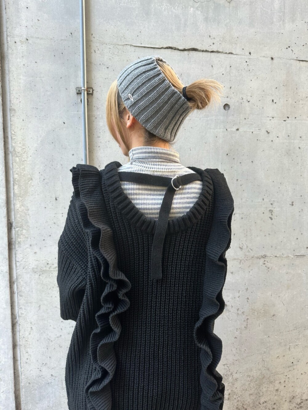 ブラック系のスニーカー、ブラック系のニット/セーター、レッド系のハンドバッグを着用したレディースの冬コーディネートの10枚目の写真