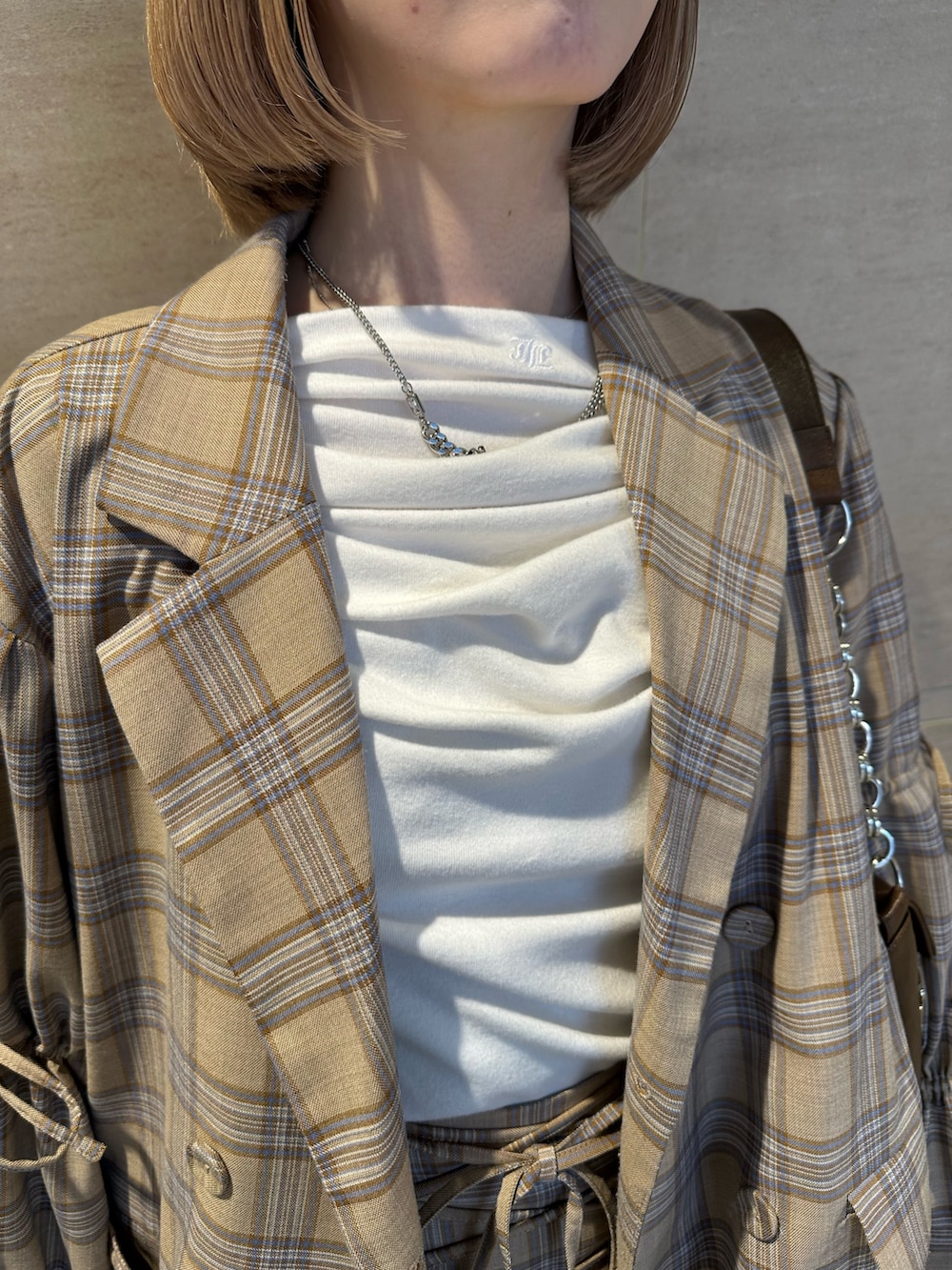 ベージュ系のテーラードジャケット、ベージュ系のスカート、ホワイト系のTシャツ/カットソーを着用したレディースの春コーディネートの8枚目の写真