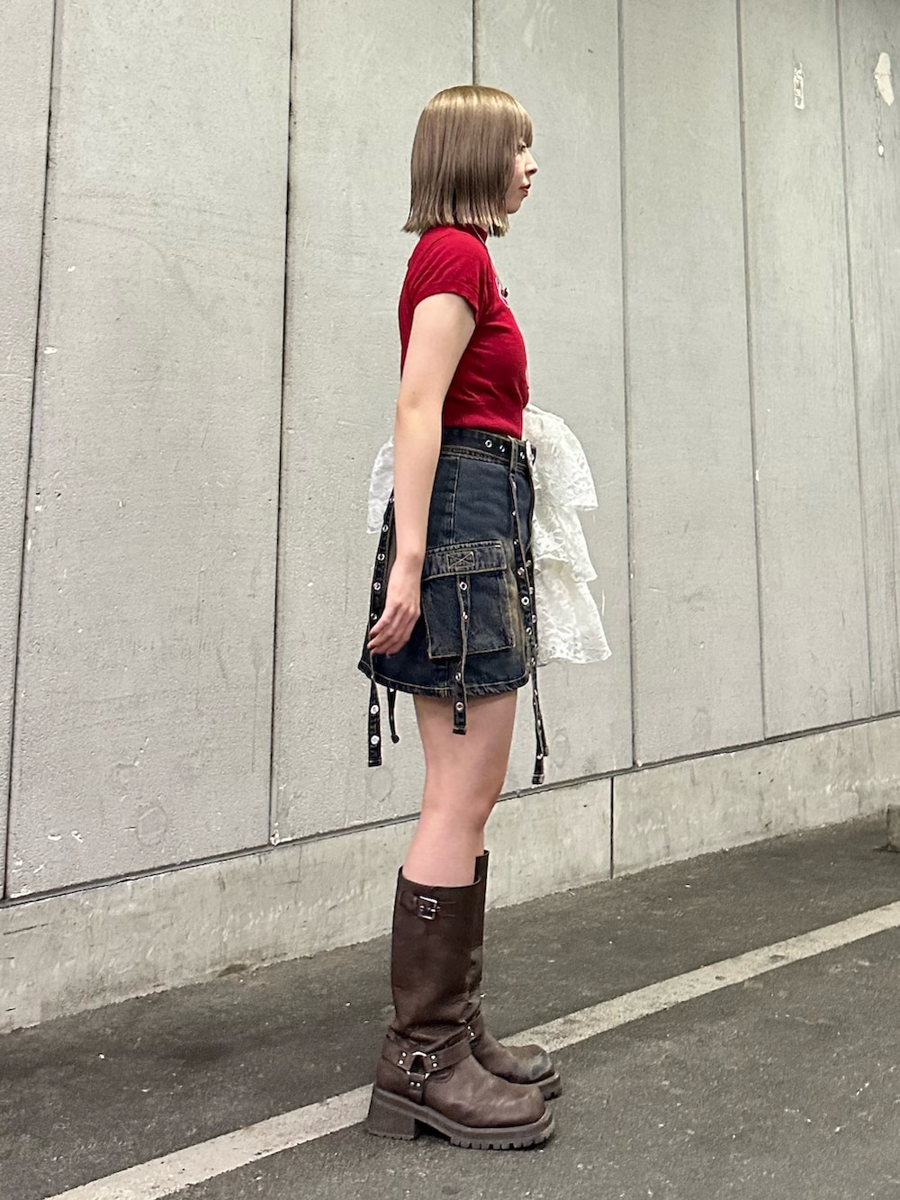 レッド系のニット/セーター、ブルー系のスカート、ブラウン系のブーツを着用したレディースの春コーディネートの6枚目の写真