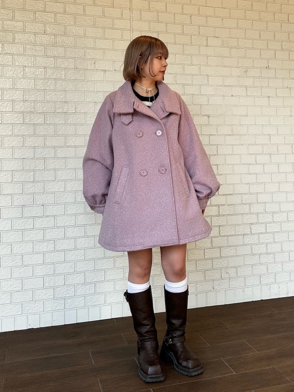 ブラウン系のブーツ、ピンク系のその他アウター、ホワイト系のスカートを着用したレディースの秋コーディネートの2枚目の写真