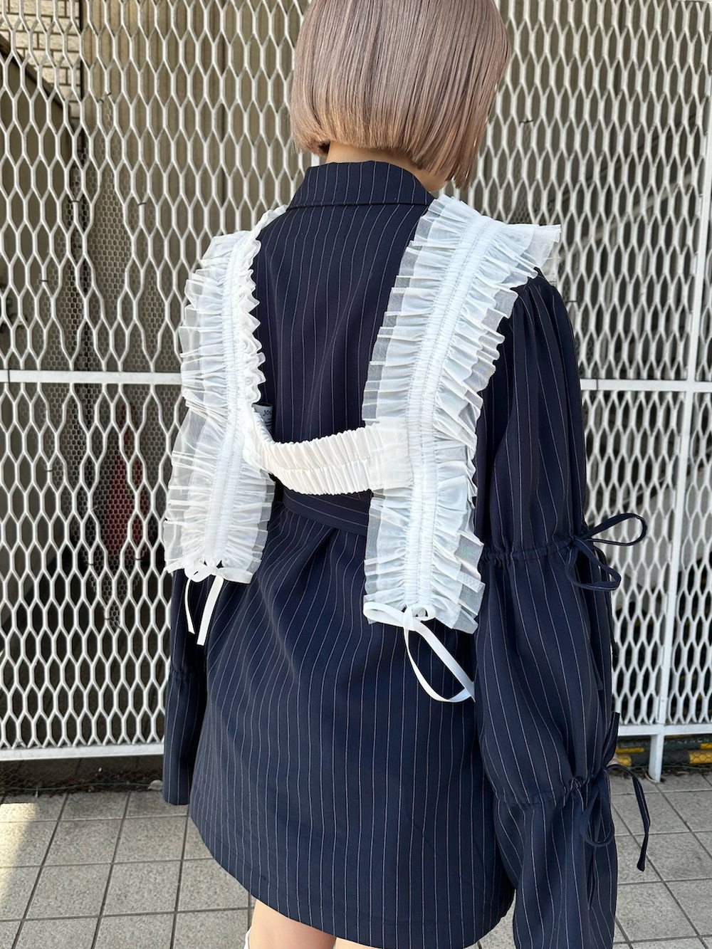 ブルー系のテーラードジャケット、ホワイト系のTシャツ/カットソー、ブラウン系のブーツを着用したレディースの冬コーディネートの9枚目の写真