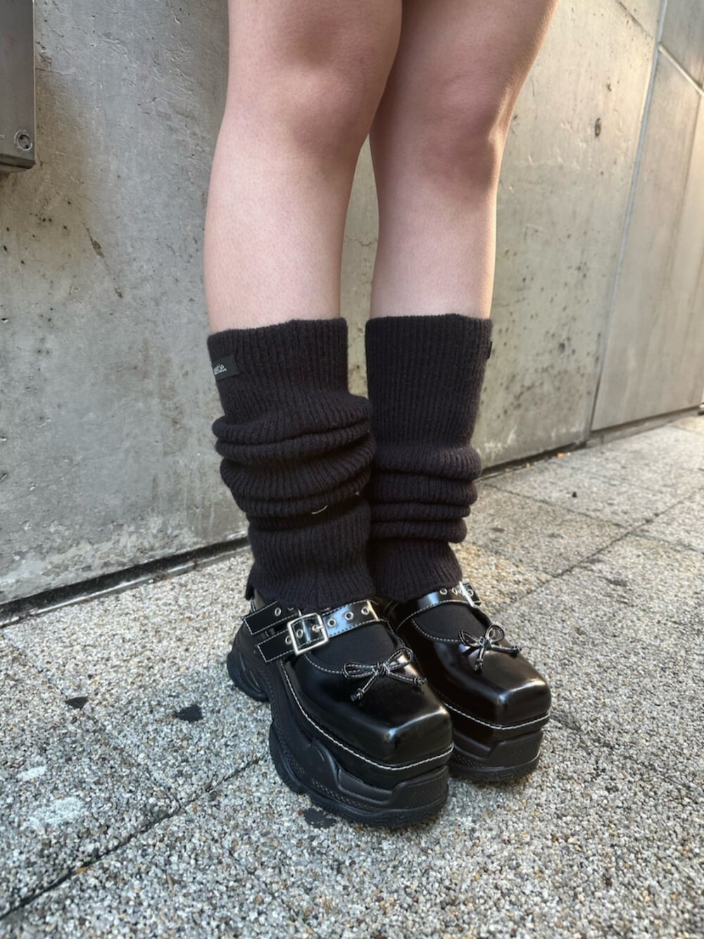 ブラック系のスニーカー、ブラック系のニット/セーター、レッド系のハンドバッグを着用したレディースの冬コーディネートの8枚目の写真