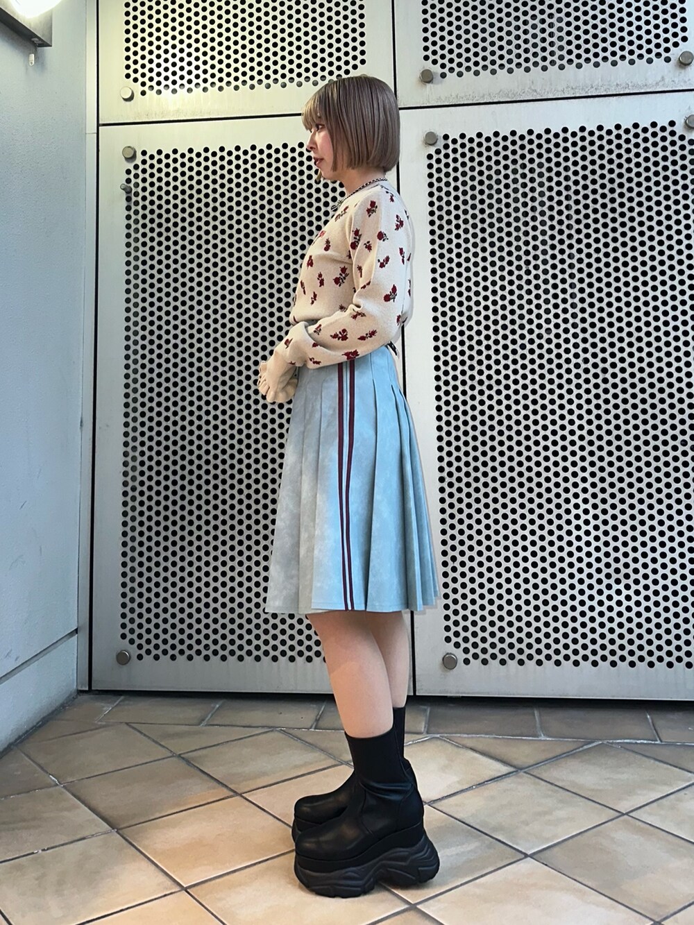 ホワイト系のニット/セーター、ブルー系のスカート、ブラック系のブーツを着用したレディースの冬コーディネートの3枚目の写真