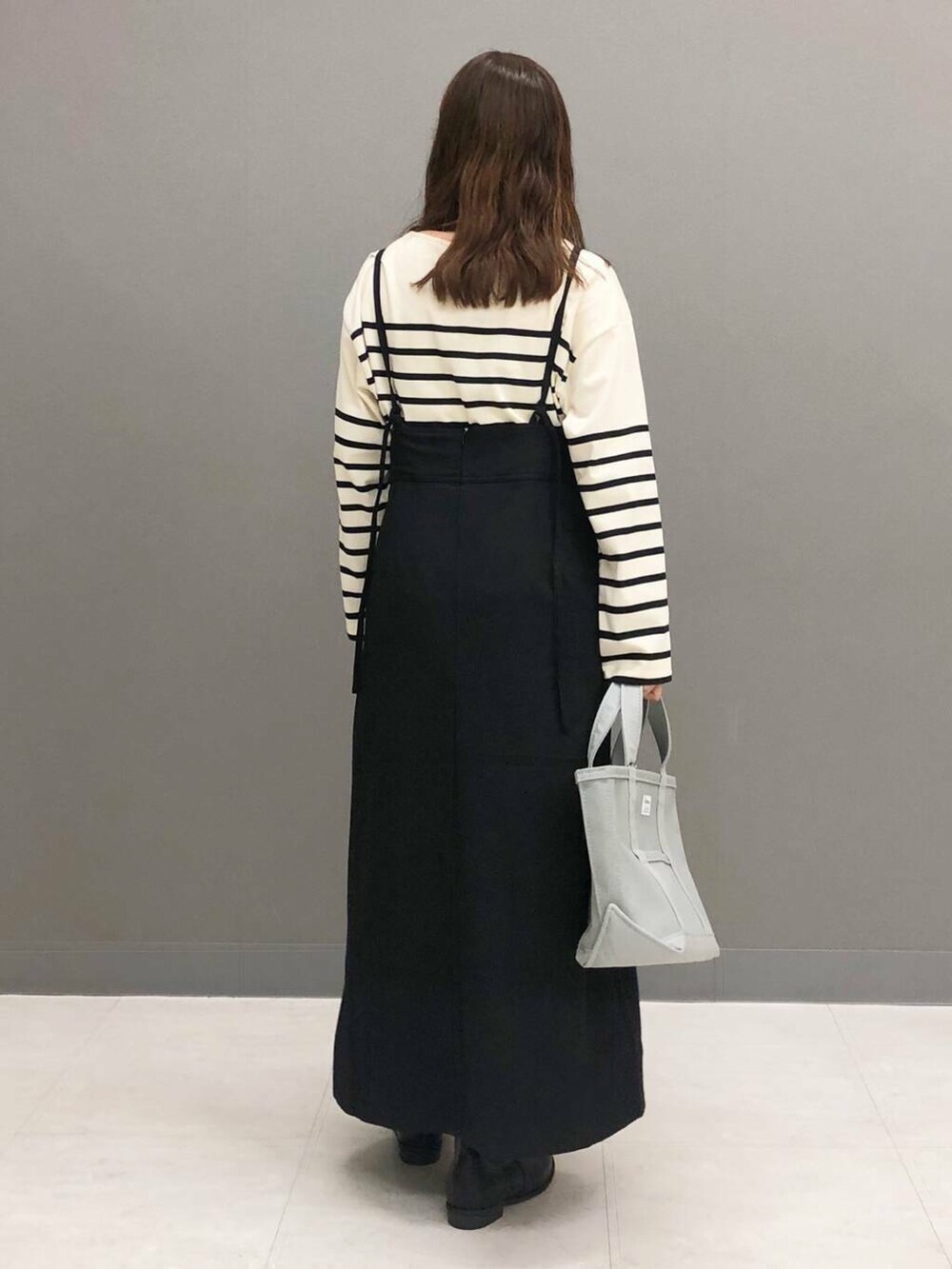 ホワイト系のTシャツ/カットソー、ブラック系のブーツ、ブラック系のワンピースを着用したレディースの秋コーディネートの3枚目の写真