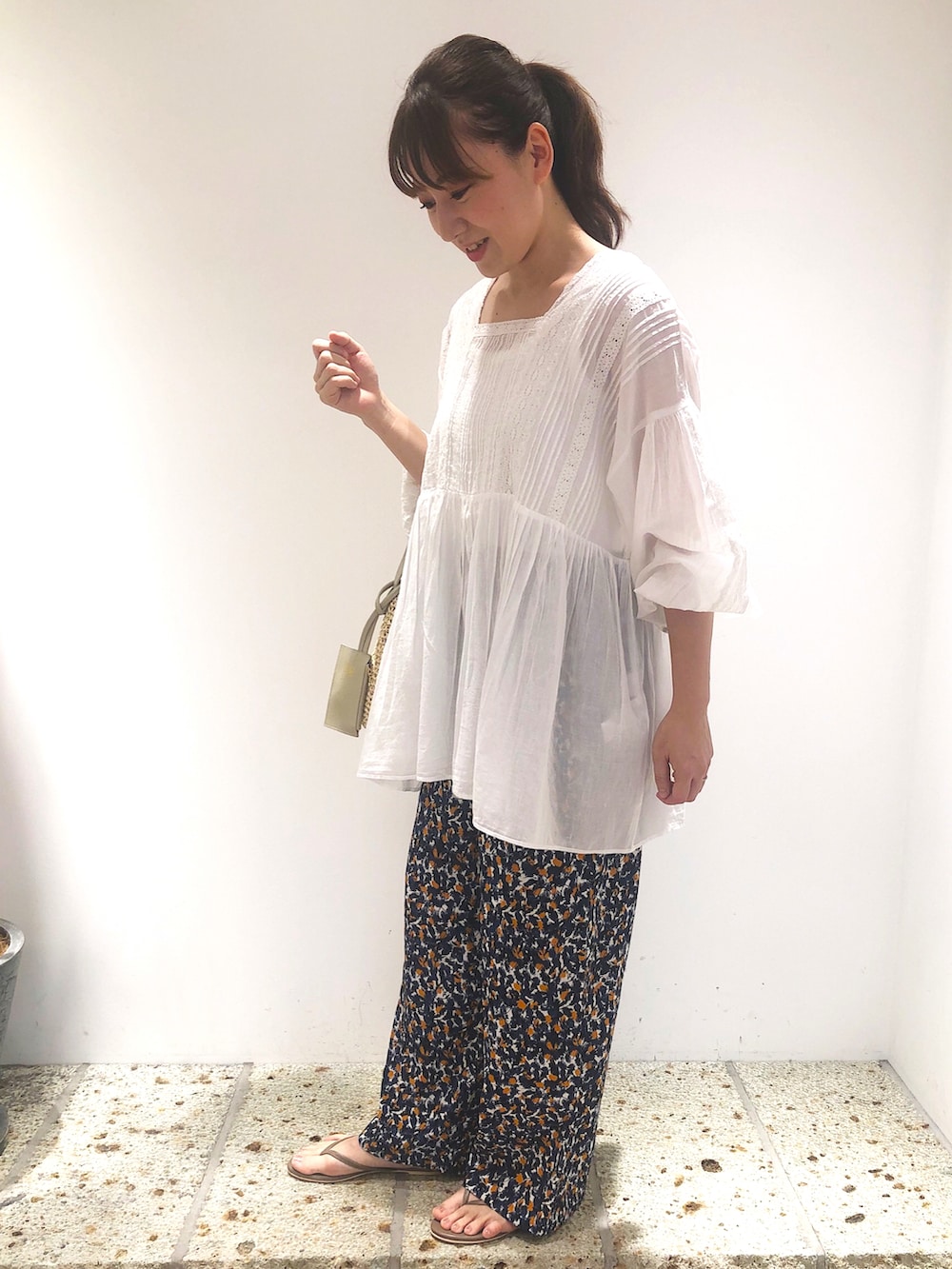 ベージュ系のトートバッグ、ブルー系のその他パンツ、ホワイト系のトップスを着用したレディースの春コーディネートの2枚目の写真