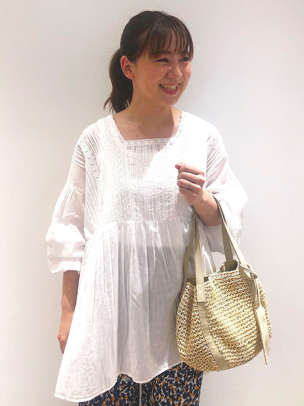 ベージュ系のトートバッグ、ブルー系のその他パンツ、ホワイト系のトップスを着用したレディースの春コーディネートの3枚目の写真