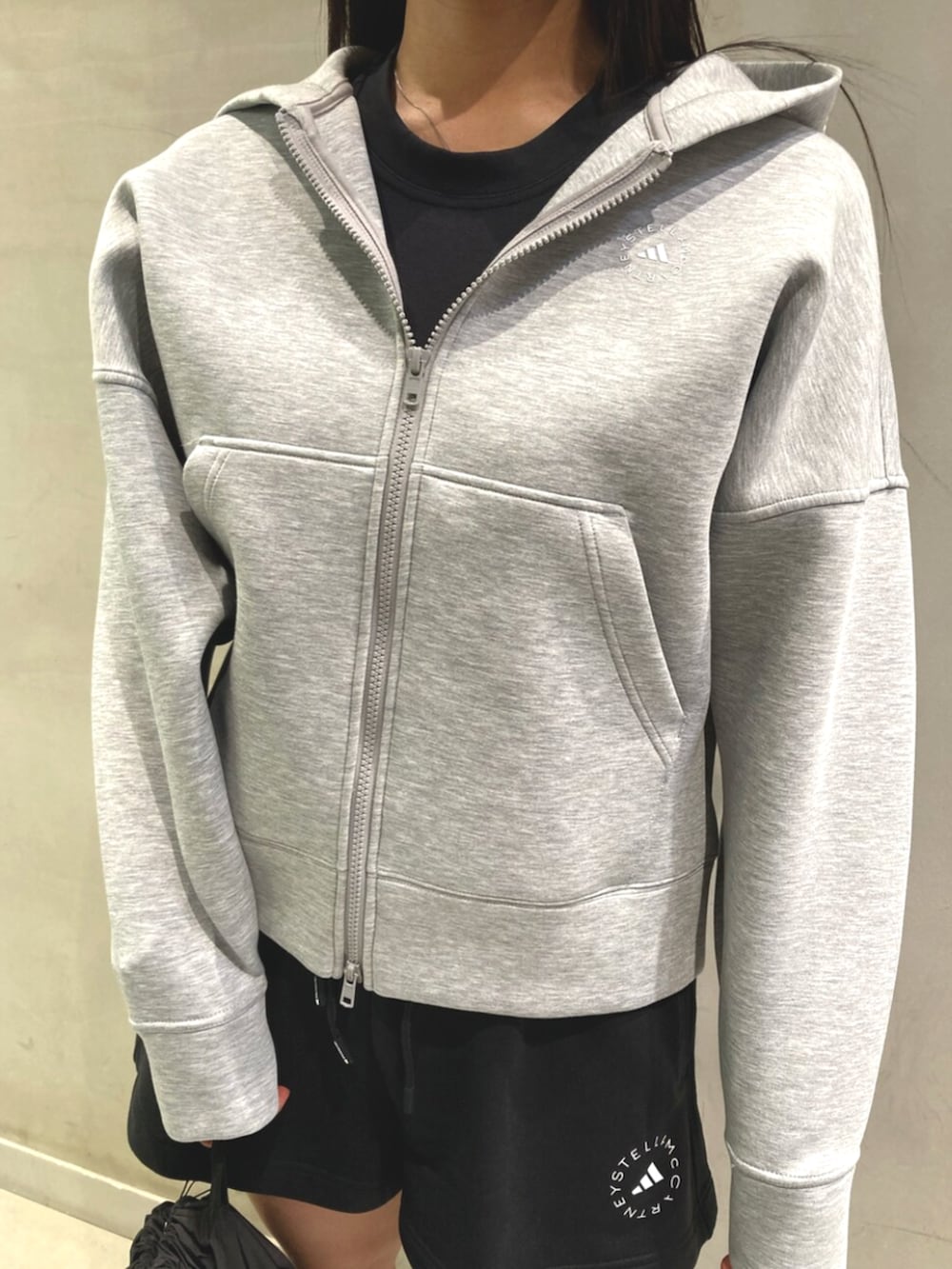 グレー系のパーカー、ブラック系のタンクトップ、ブラック系のその他パンツを着用したレディースの夏コーディネートの2枚目の写真