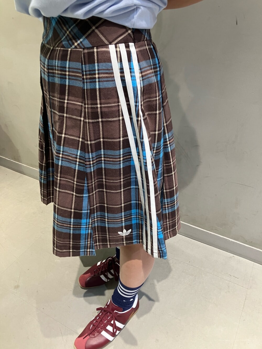 ブラウン系のスカート、ブラウン系のショルダーバッグ、ブルー系のTシャツ/カットソーを着用したレディースの冬コーディネートの3枚目の写真