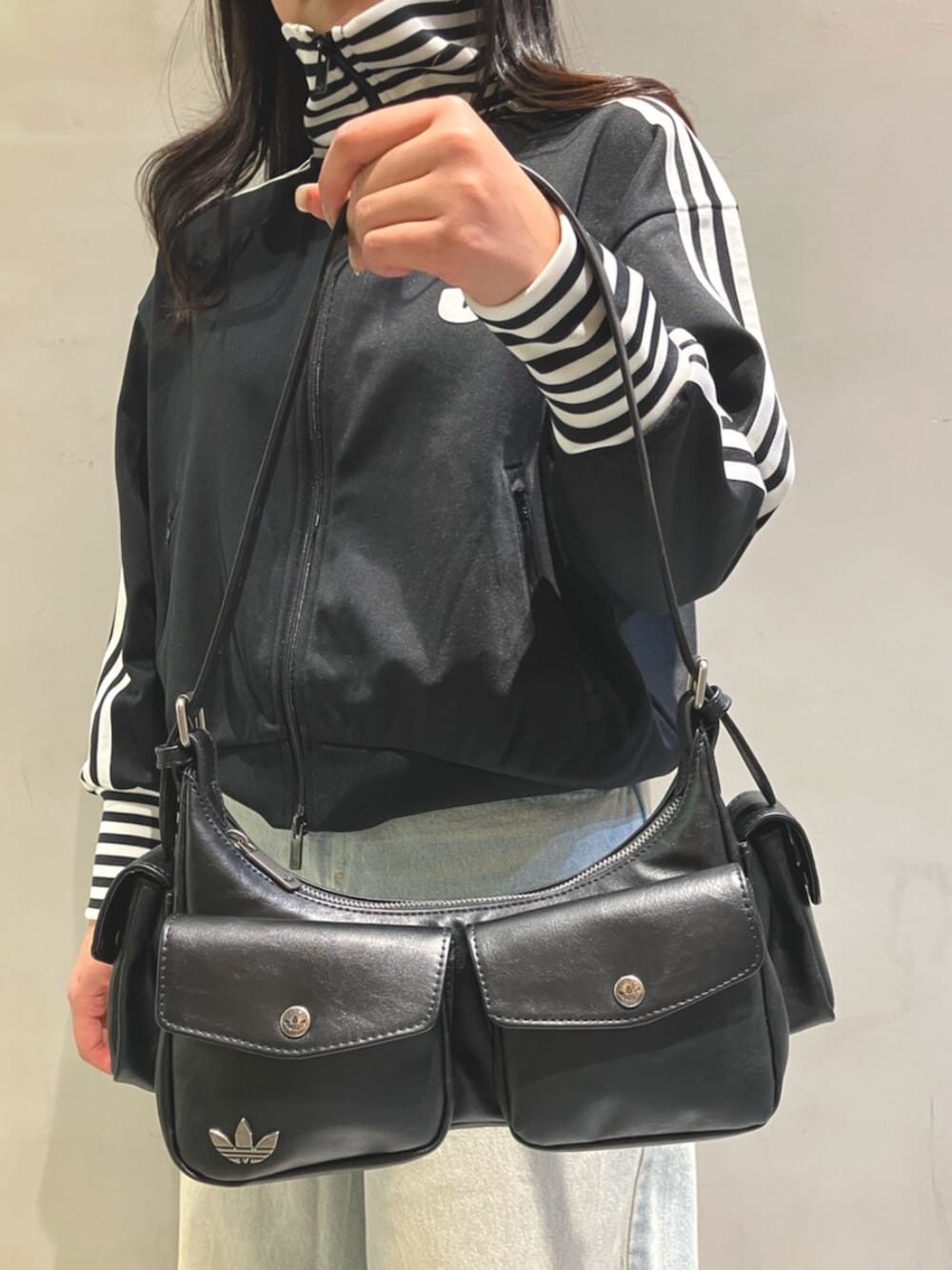 ブラック系のジャージ、ブルー系のデニムパンツ、ホワイト系のスニーカーを着用したレディースの冬コーディネートの4枚目の写真