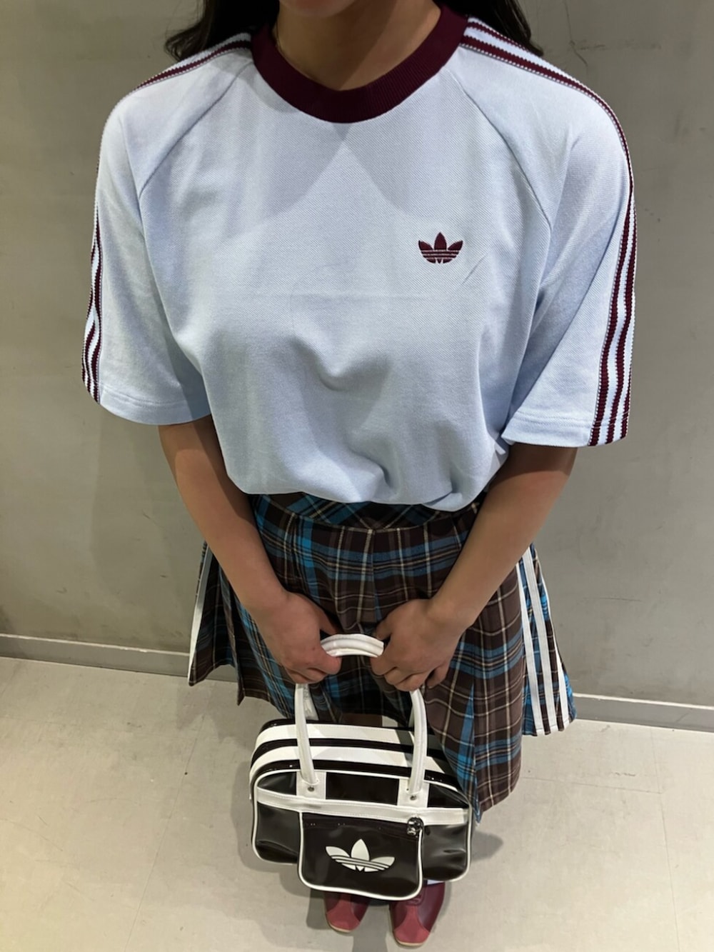 ブラウン系のスカート、ブラウン系のショルダーバッグ、ブルー系のTシャツ/カットソーを着用したレディースの冬コーディネートの2枚目の写真