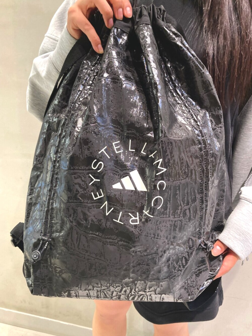 グレー系のパーカー、ブラック系のタンクトップ、ブラック系のその他パンツを着用したレディースの夏コーディネートの3枚目の写真