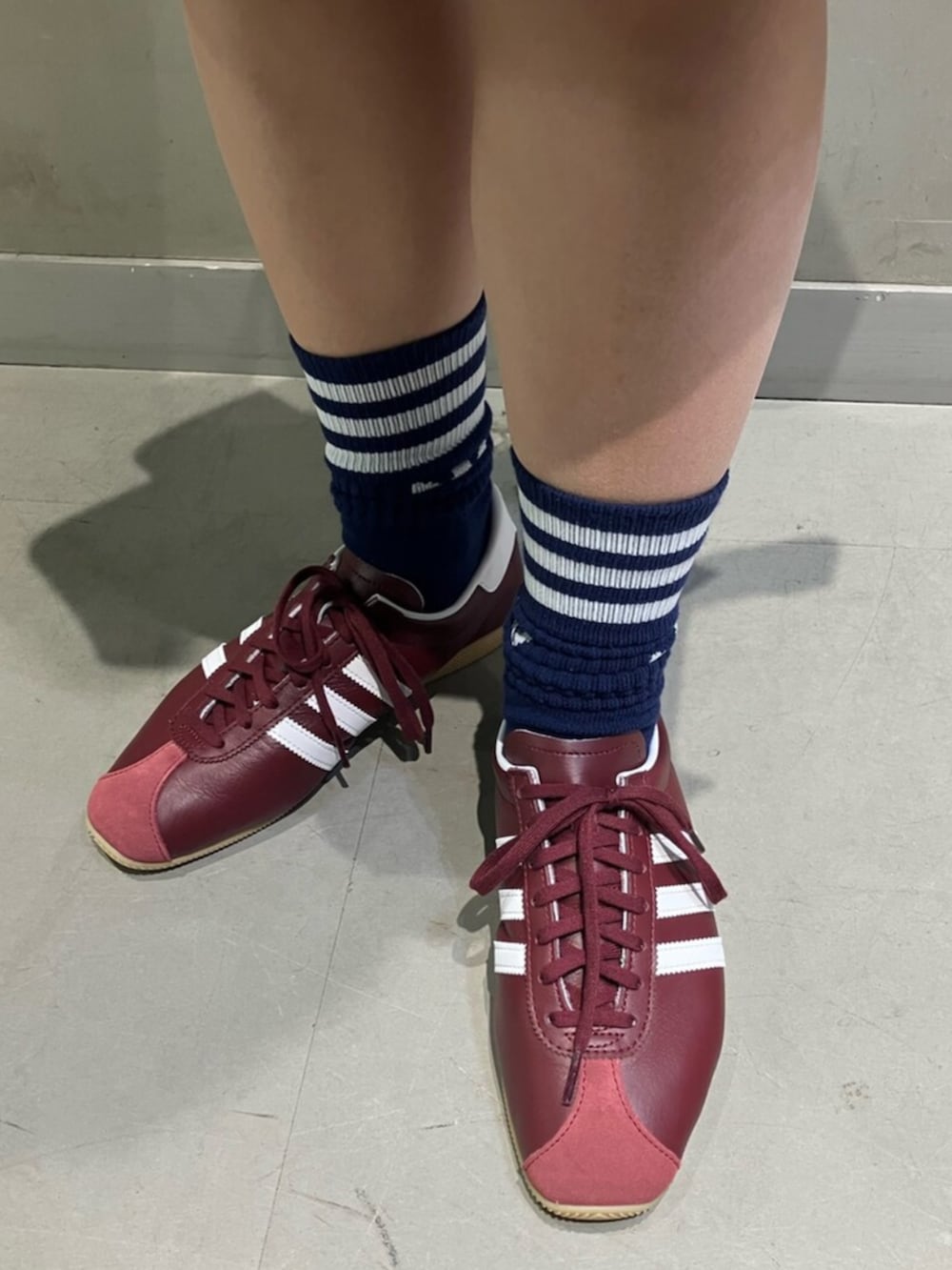 ブラウン系のスカート、ブラウン系のショルダーバッグ、ブルー系のTシャツ/カットソーを着用したレディースの冬コーディネートの4枚目の写真