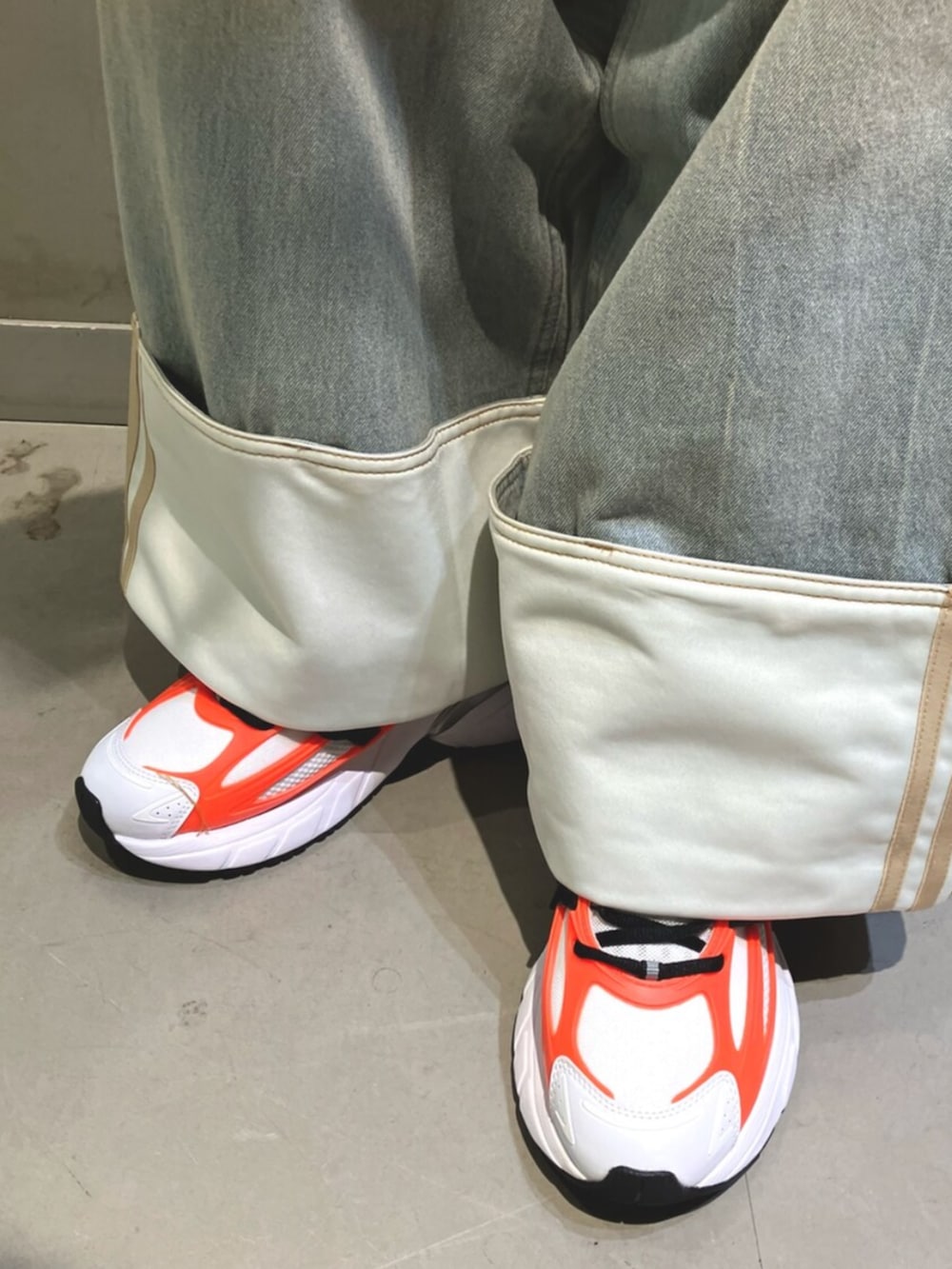 ブラック系のジャージ、ブルー系のデニムパンツ、ホワイト系のスニーカーを着用したレディースの冬コーディネートの3枚目の写真