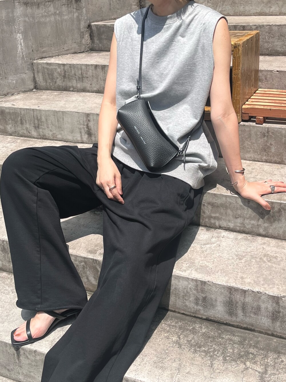 ブラック系のショルダーバッグを着用したレディースの夏コーディネートの2枚目の写真