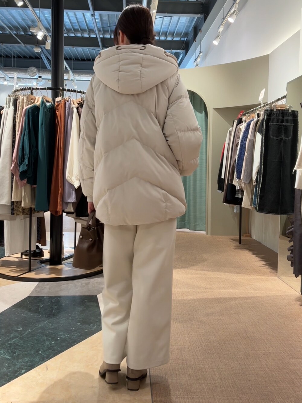 ホワイト系のダウンジャケット/コート、ホワイト系のその他パンツ、ベージュ系のブーツを着用したレディースの冬コーディネートの2枚目の写真