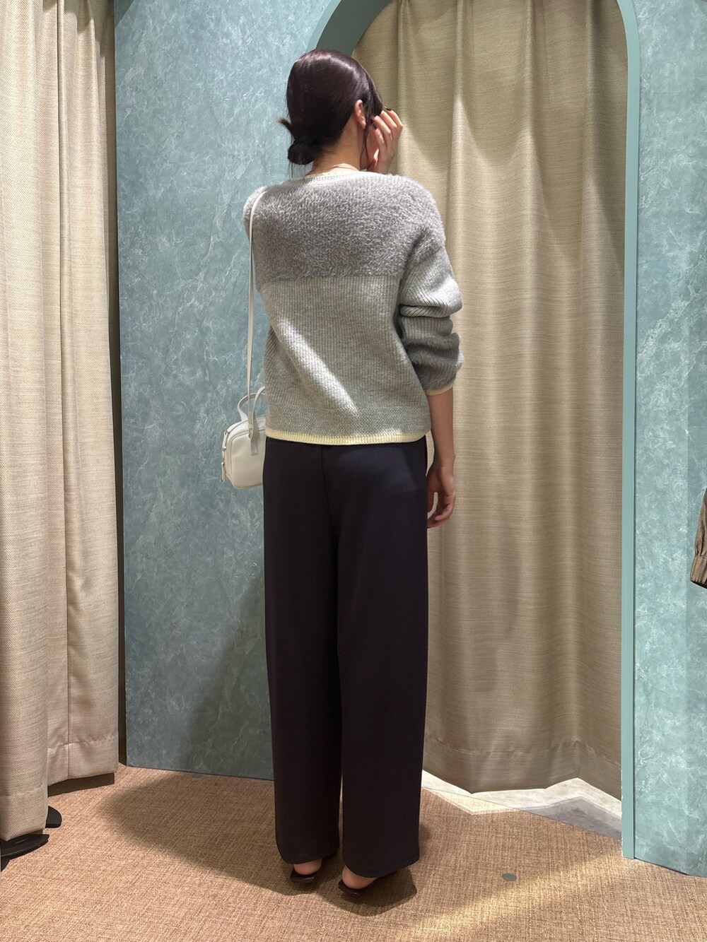 グレー系のニット/セーター、グレー系のその他パンツを着用したレディースの冬コーディネートの2枚目の写真