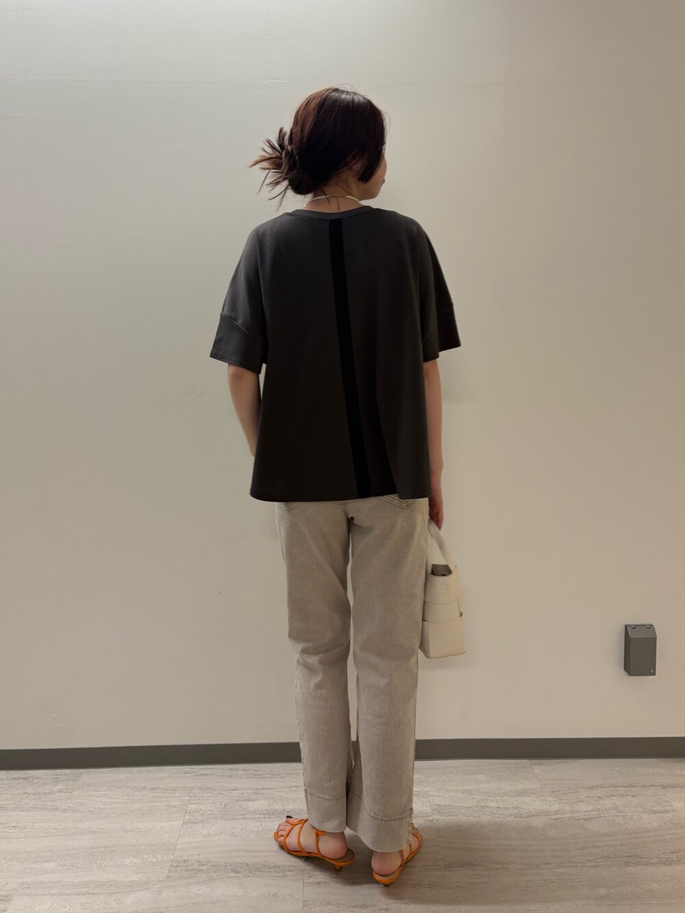 グレー系のTシャツ/カットソー、グレー系のデニムパンツ、ホワイト系のトートバッグを着用したレディースの春コーディネートの2枚目の写真