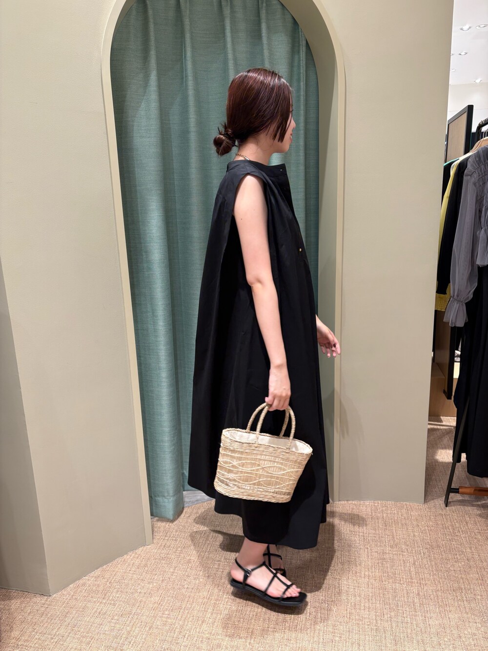 ブラック系のワンピース、ベージュ系のトートバッグを着用したレディースの春コーディネートの2枚目の写真