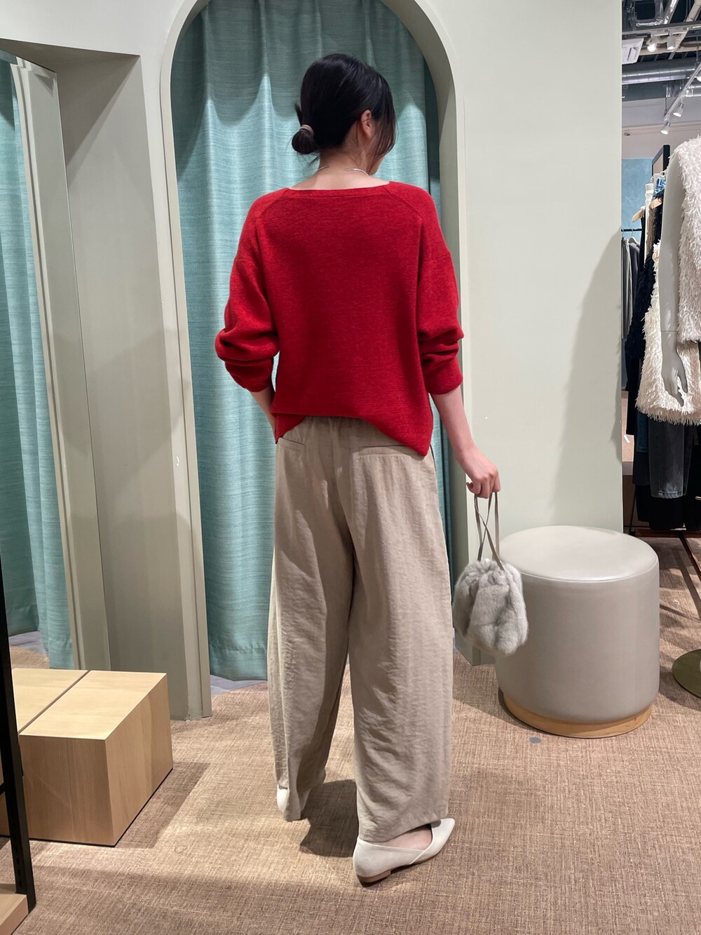 レッド系のニット/セーター、ベージュ系のその他パンツ、ブラウン系のトートバッグを着用したレディースの秋コーディネートの2枚目の写真