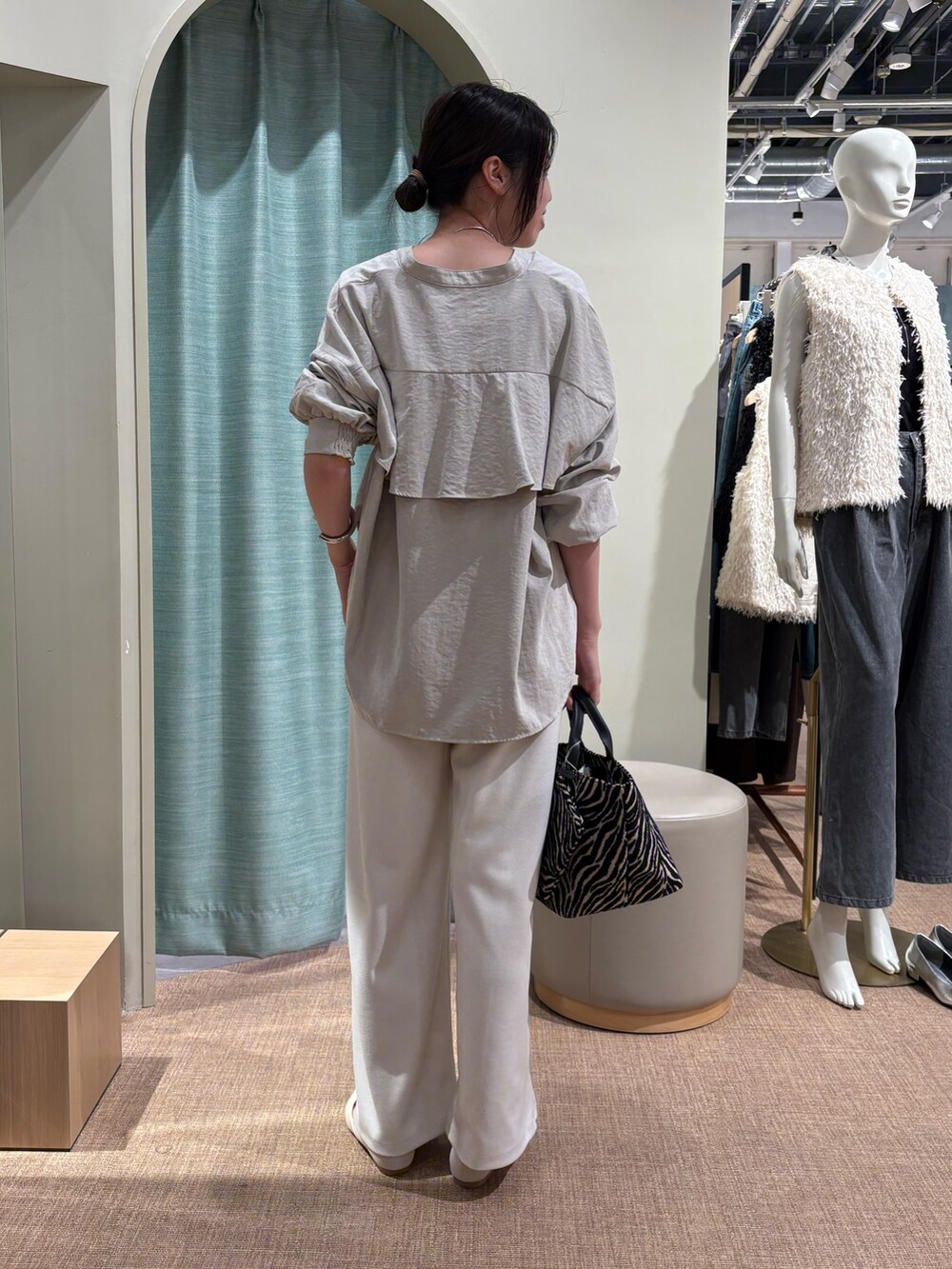 グレー系のシャツ/ブラウス、ホワイト系のその他パンツ、ブラック系のトートバッグを着用したレディースの秋コーディネートの2枚目の写真