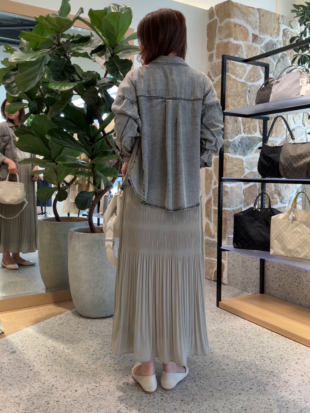 グレー系のシャツ/ブラウス、ホワイト系のニット/セーター、グレー系のスカートを着用したレディースの春コーディネートの3枚目の写真