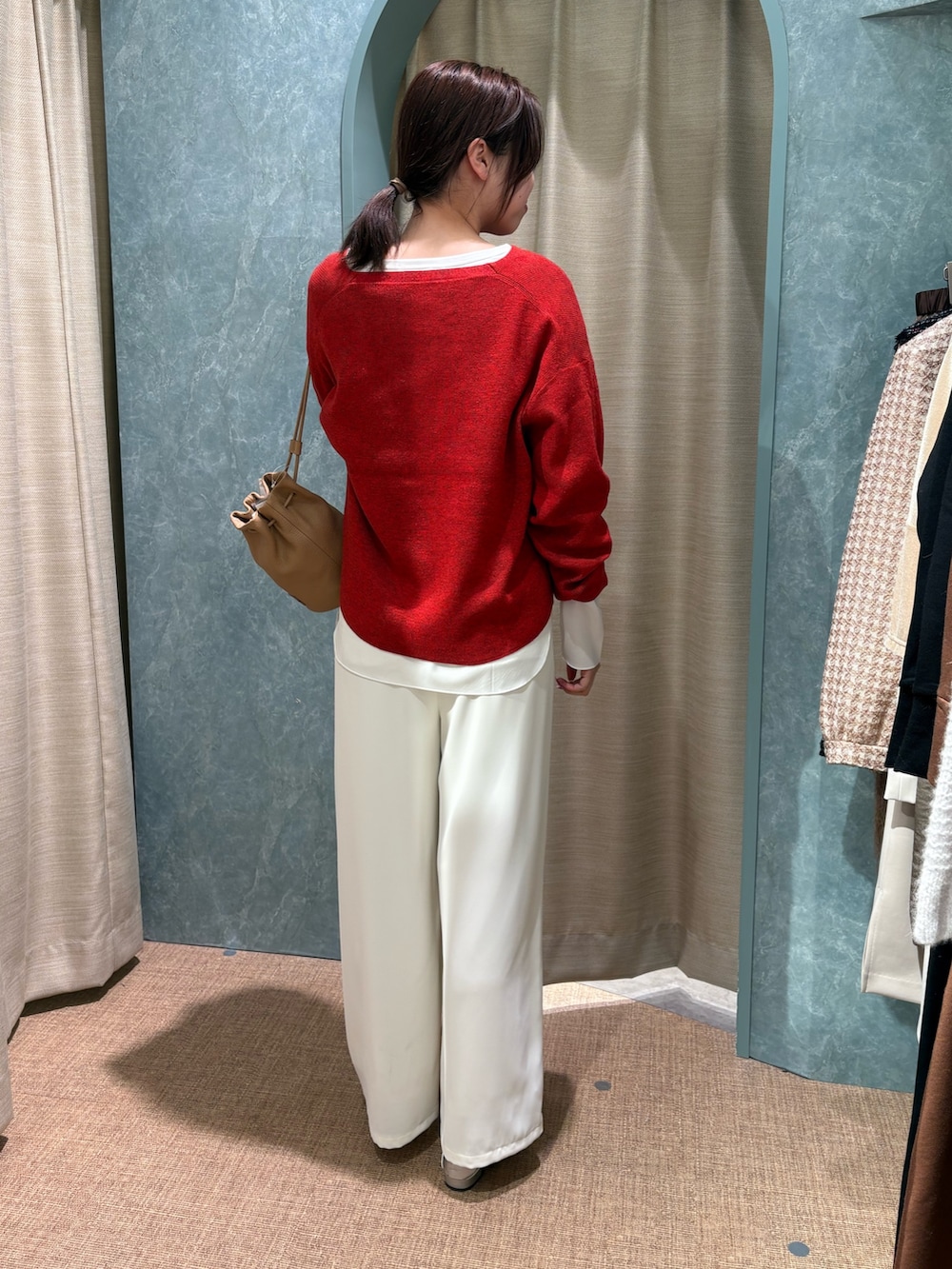 レッド系のニット/セーター、ホワイト系のTシャツ/カットソー、ホワイト系のその他パンツを着用したレディースの冬コーディネートの2枚目の写真