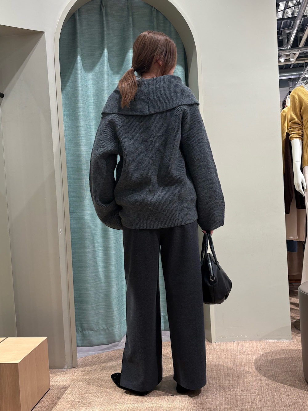 グレー系のニット/セーター、ブラック系のトートバッグ、グレー系のその他パンツを着用したレディースの秋コーディネートの2枚目の写真