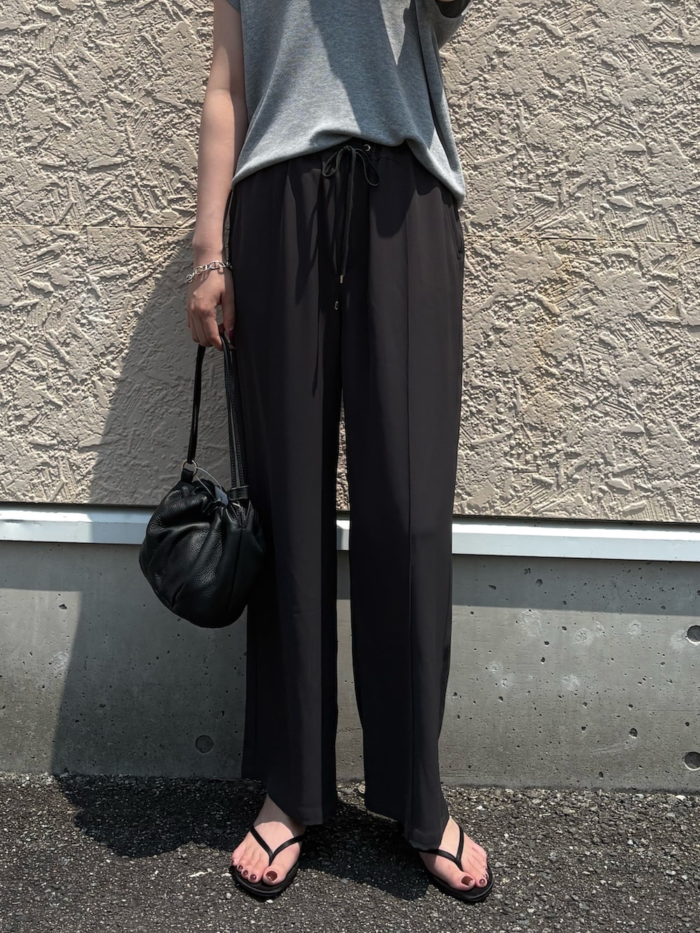 グレー系のニット/セーター、ブラック系のTシャツ/カットソー、ブラック系のトートバッグを着用したレディースの夏コーディネートの2枚目の写真
