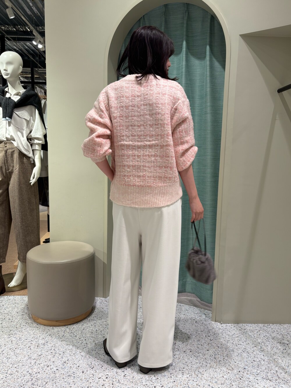 ピンク系のニット/セーター、ホワイト系のその他パンツ、ブラック系のトートバッグを着用したレディースの秋コーディネートの2枚目の写真