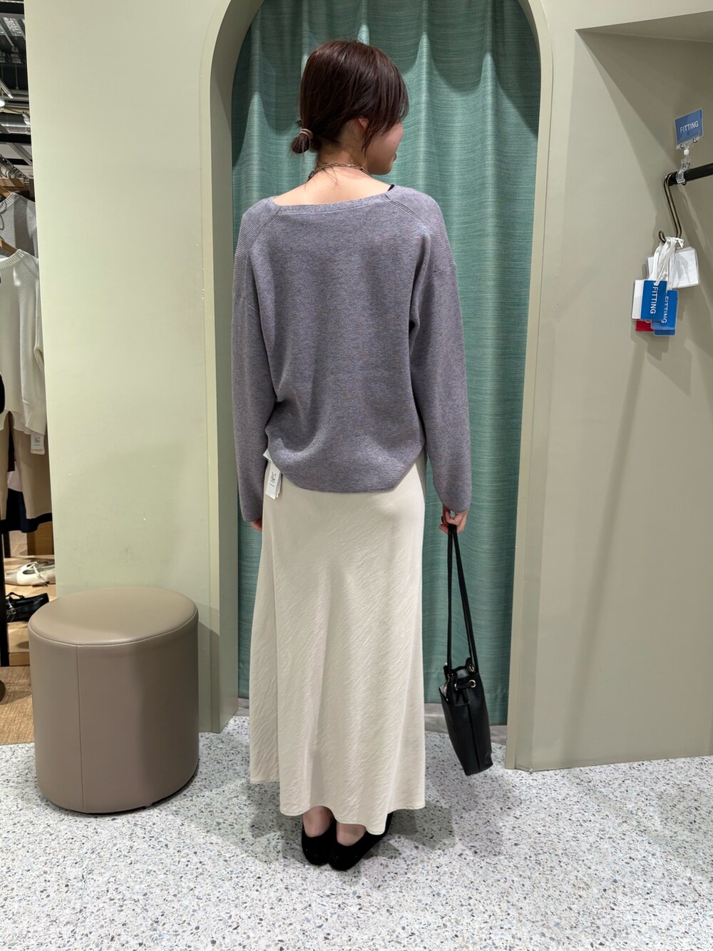 グレー系のニット/セーター、ベージュ系のスカートを着用したレディースの冬コーディネートの2枚目の写真