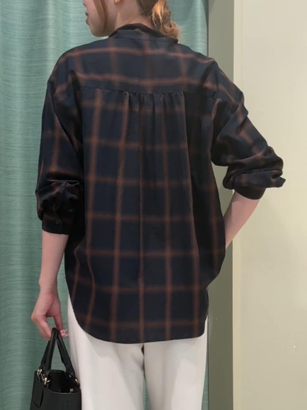 ブルー系のシャツ/ブラウス、ホワイト系のその他パンツ、ブラック系のトートバッグを着用したレディースの秋コーディネートの3枚目の写真
