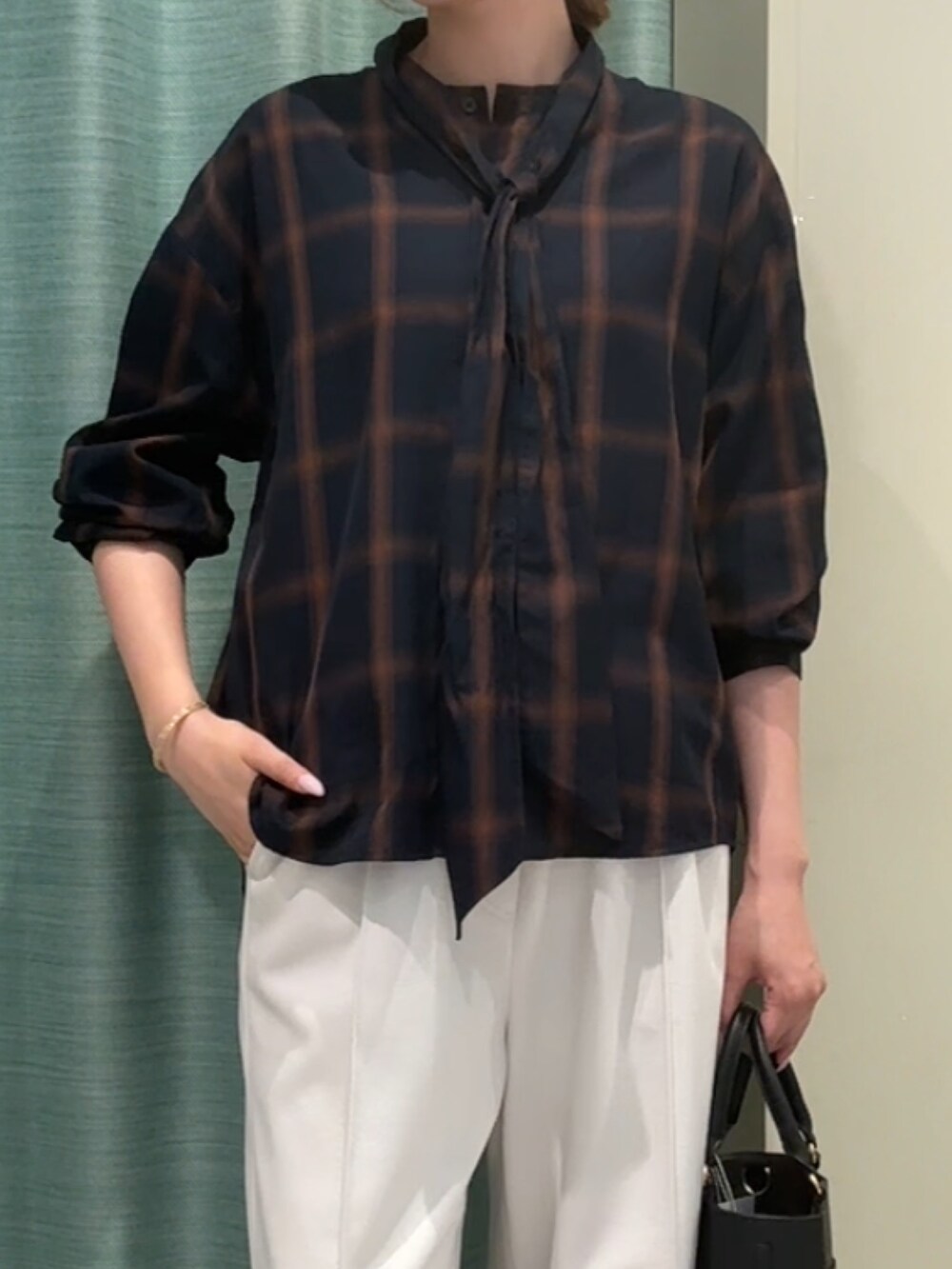 ブルー系のシャツ/ブラウス、ホワイト系のその他パンツ、ブラック系のトートバッグを着用したレディースの秋コーディネートの2枚目の写真