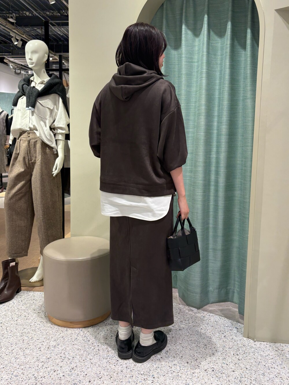 グレー系のワンピース、ブラック系のトートバッグを着用したレディースの秋コーディネートの2枚目の写真