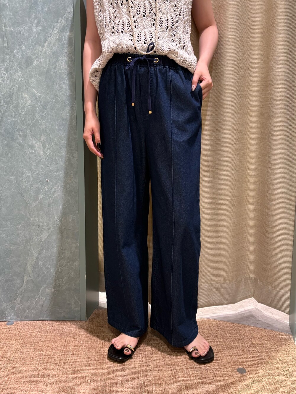 ホワイト系のニット/セーター、ブルー系のデニムパンツを着用したレディースの夏コーディネートの2枚目の写真