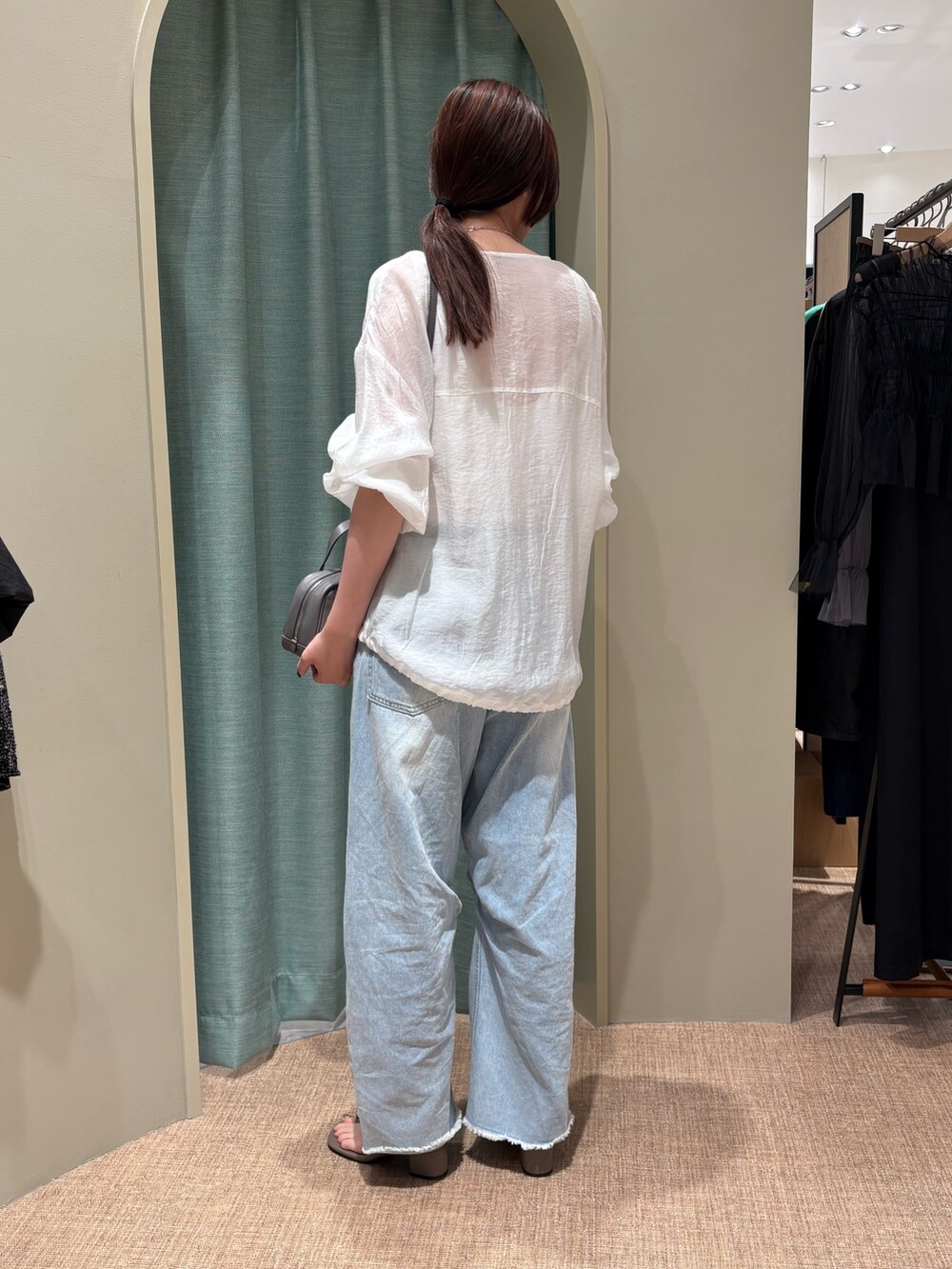 ホワイト系のブルゾン、ブルー系のその他パンツ、ベージュ系のサンダルを着用したレディースの春コーディネートの2枚目の写真