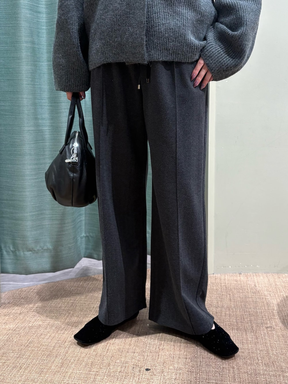 グレー系のニット/セーター、ブラック系のトートバッグ、グレー系のその他パンツを着用したレディースの秋コーディネートの3枚目の写真