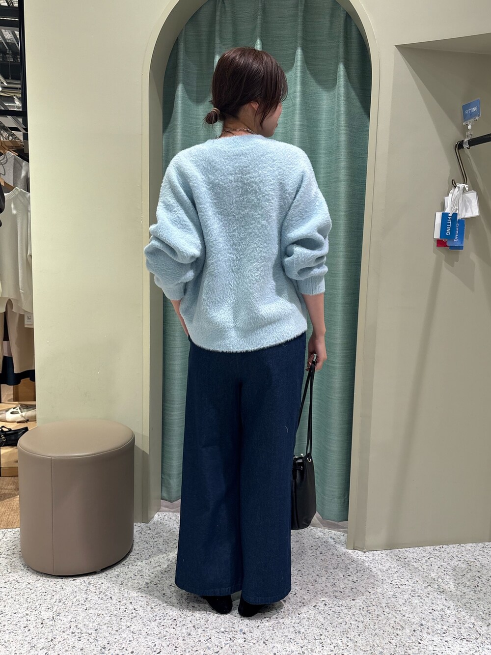 ブルー系のニット/セーター、ブルー系のデニムパンツを着用したレディースの冬コーディネートの2枚目の写真