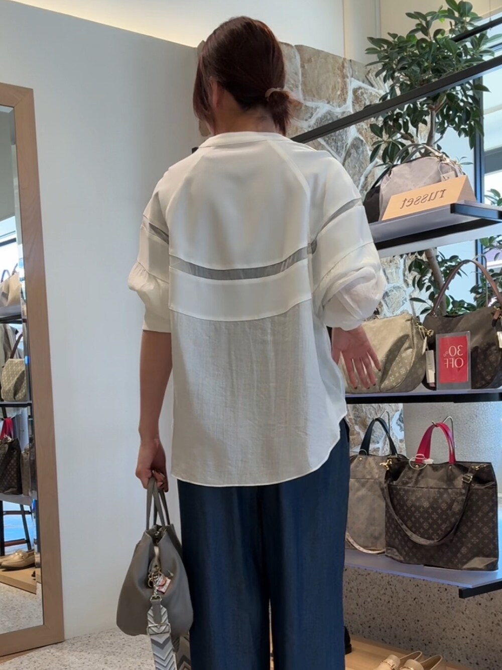 ホワイト系のノーカラージャケット、ブルー系のその他パンツ、グレー系のトートバッグを着用したレディースの春コーディネートの2枚目の写真