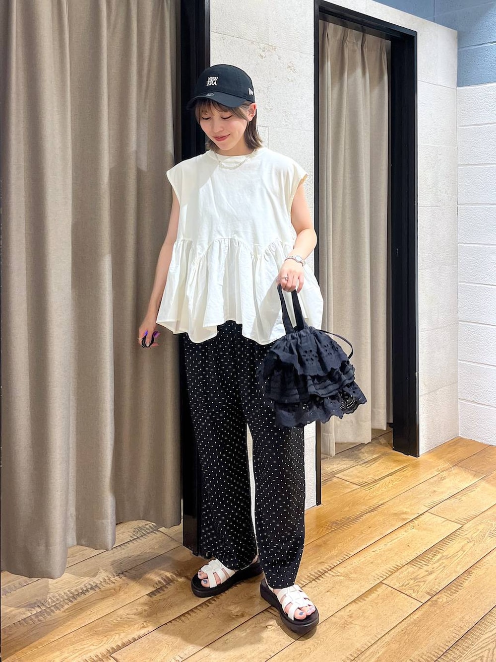 ホワイト系のTシャツ/カットソー、ホワイト系のサンダル、ブラック系のハンドバッグを着用したレディースの夏コーディネートの2枚目の写真