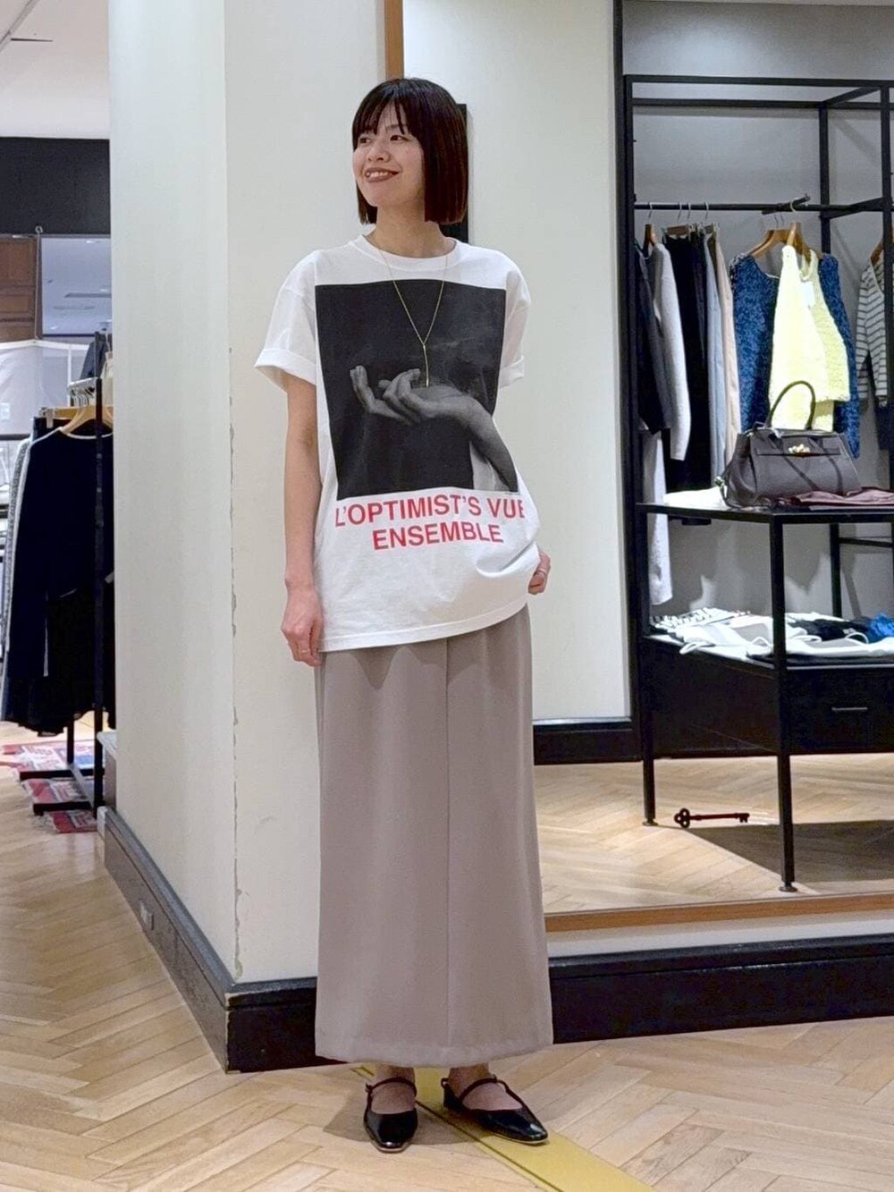 ブラック系のショルダーバッグ、ホワイト系のシャツ/ブラウス、ブラック系のパンプスを着用したレディースの春コーディネートの2枚目の写真