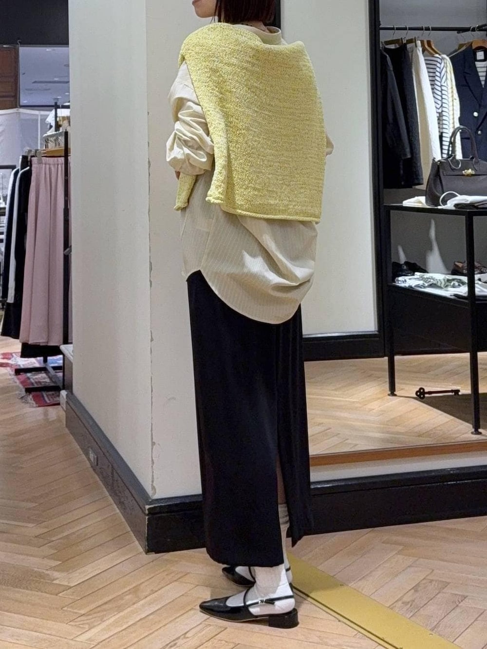 ブラック系のショルダーバッグ、イエロー系のニット/セーター、イエロー系のシャツ/ブラウスを着用したレディースの冬コーディネートの4枚目の写真