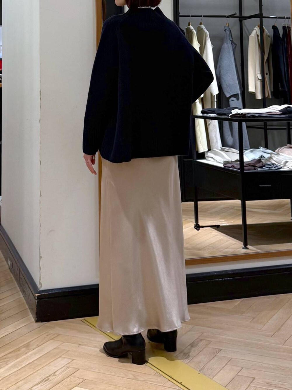 ブラック系のブーツ、ブルー系のニット/セーター、ベージュ系のスカートを着用したレディースの冬コーディネートの4枚目の写真